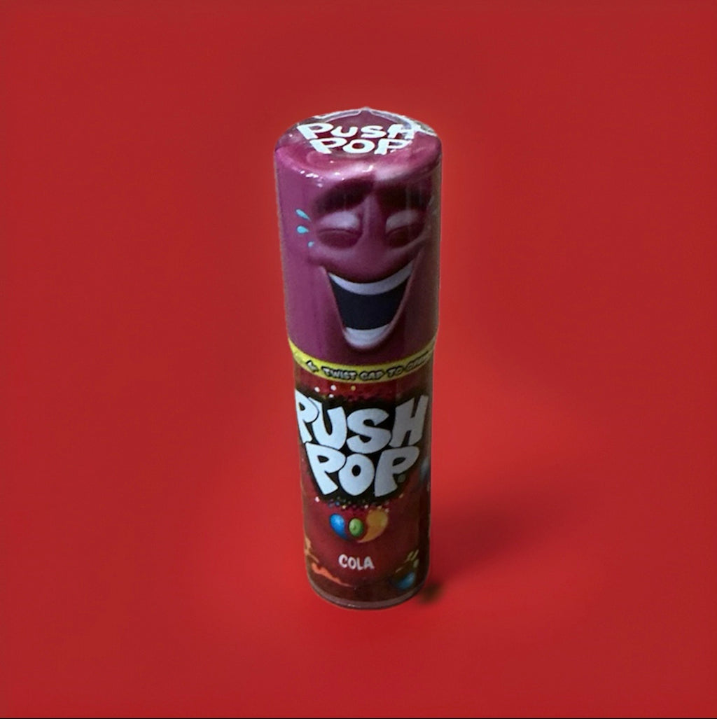 Push up cola flavour lolly in a purple plastic tube with a purple lid on a red background 