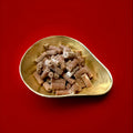 Salted caramel liquorice tubes with a salted caramel fondant centre in a gold bowl on a red background 