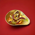 Large multicoloured jelly and foam snakes in a gold bow on a red background 