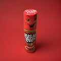 Push up strawberry flavour lolly in a red plastic tube with a red lid on a red background 