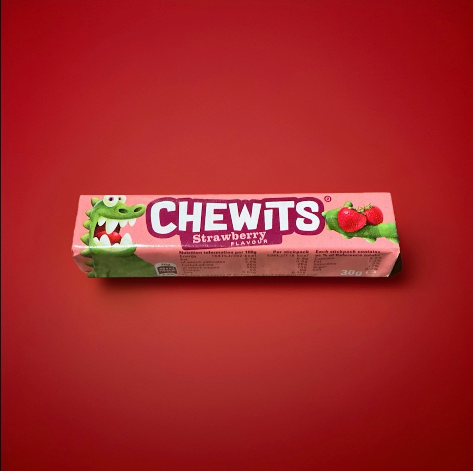 Strawberry flavoured Chewits in a pink wrapper on a red background 