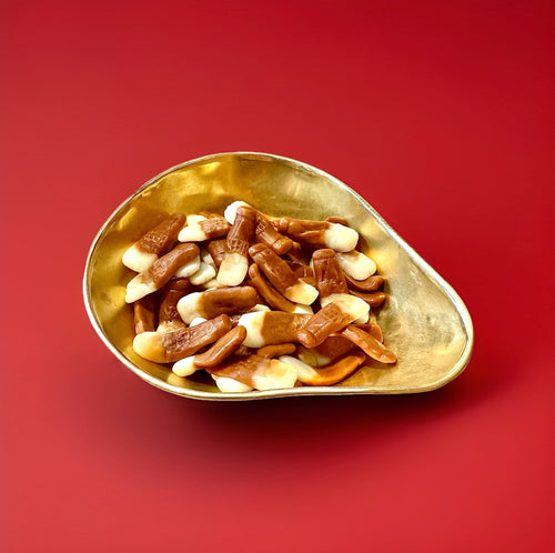 Beer flavoured pint shaped jelly sweets in a gold bowl with a red background 
