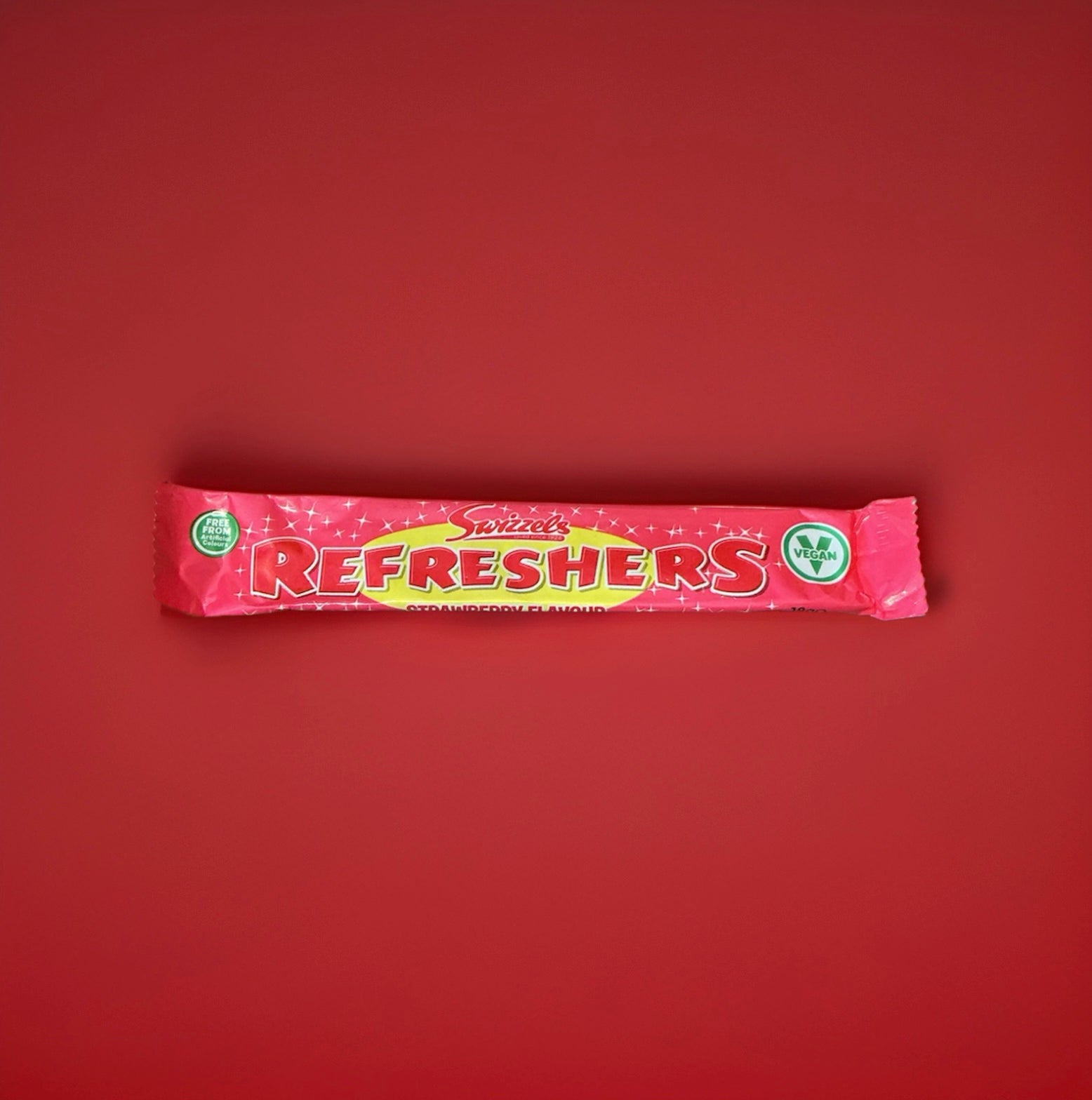 Wrapped pink strawberry flavoured refresher chew bar on a red background 