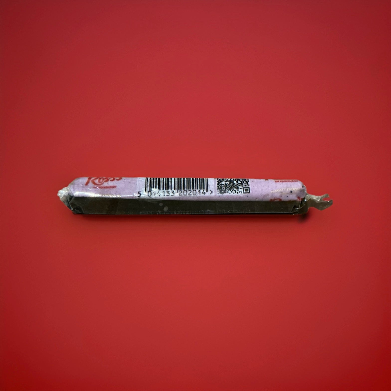 Individually wrapped black and purple chew bar with a blackcurrant and liquorice flavour on a red background 