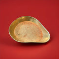 Multicoloured rainbow crystals sherbet in a gold bowl on a red background 