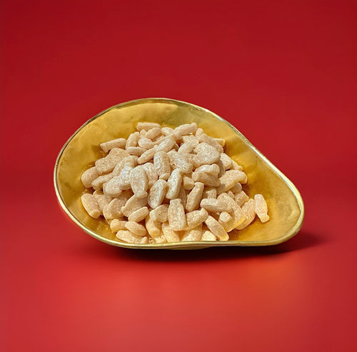 Barratt milk gums powdered dusty milk flavoured bottles in a gold bowl with a red background 