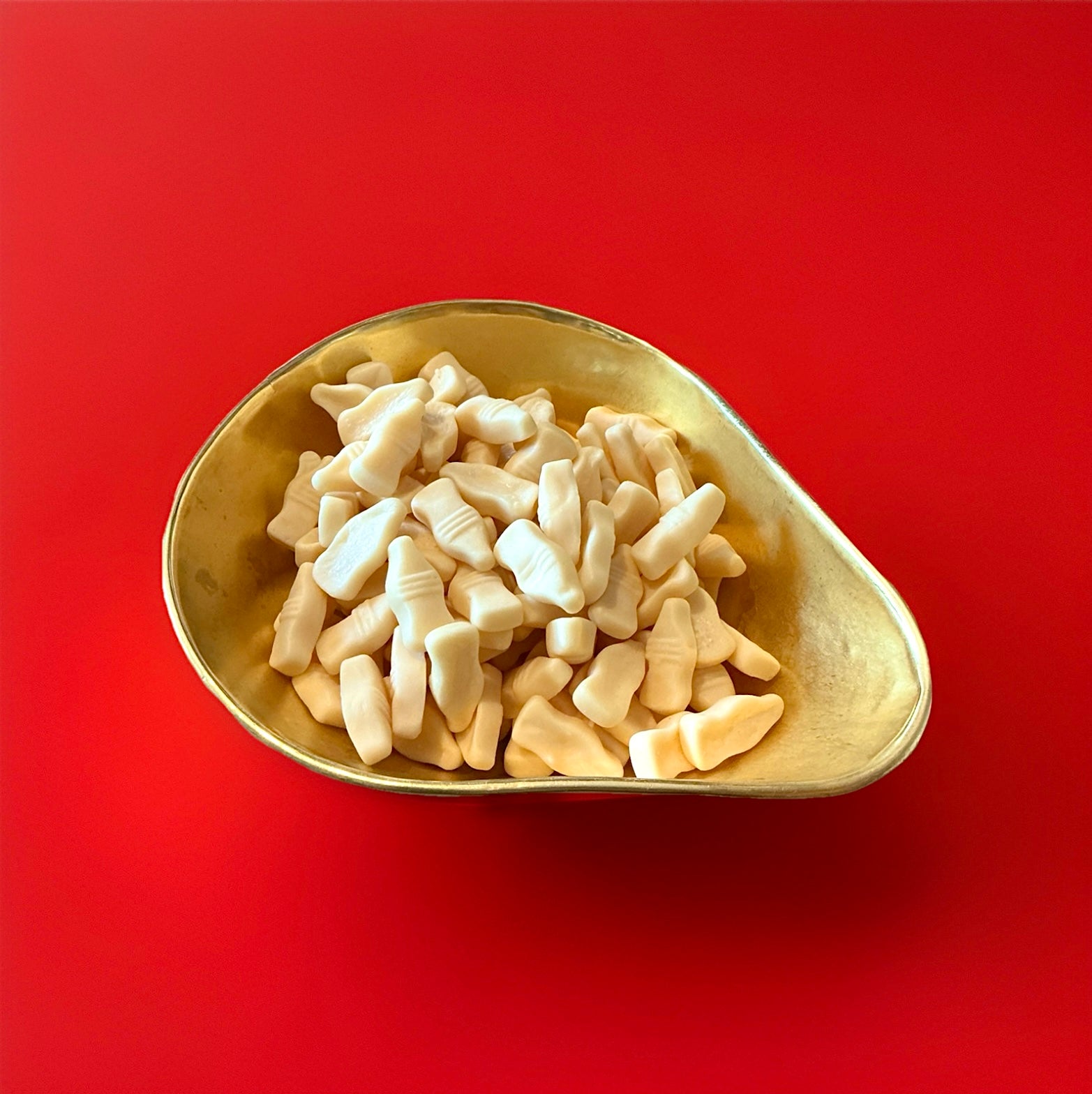 White Barrett milk bottles in a gold bowl on a red background 