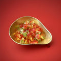 Multicoloured coloured fruit flavoured jelly sweets in the shape of rings in a gold bowl on a red background 