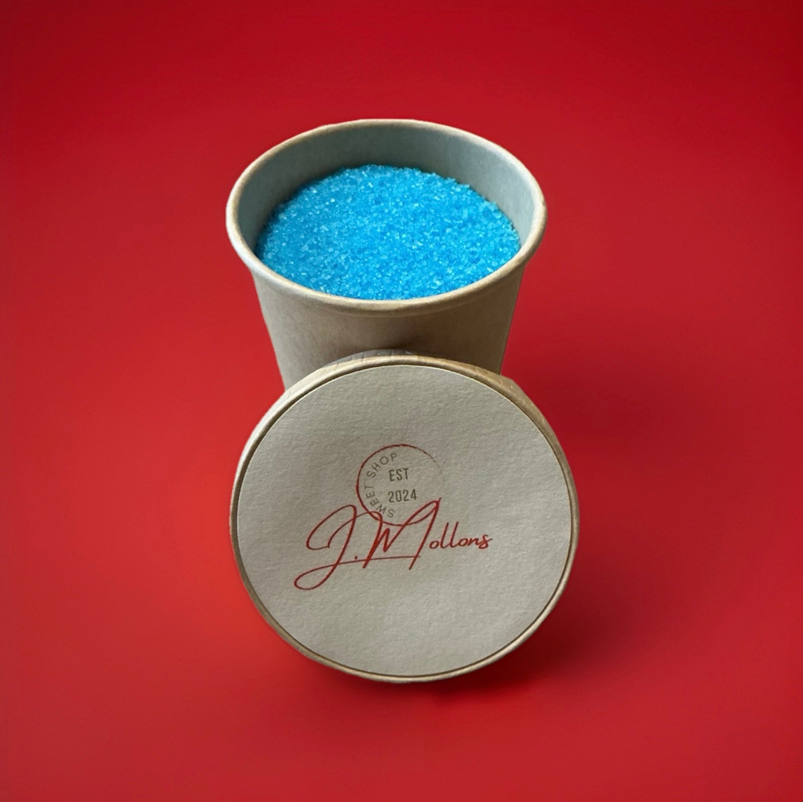 Blue coloured blue raspberry flavoured sherbet in a brown paper pot on a red background 
