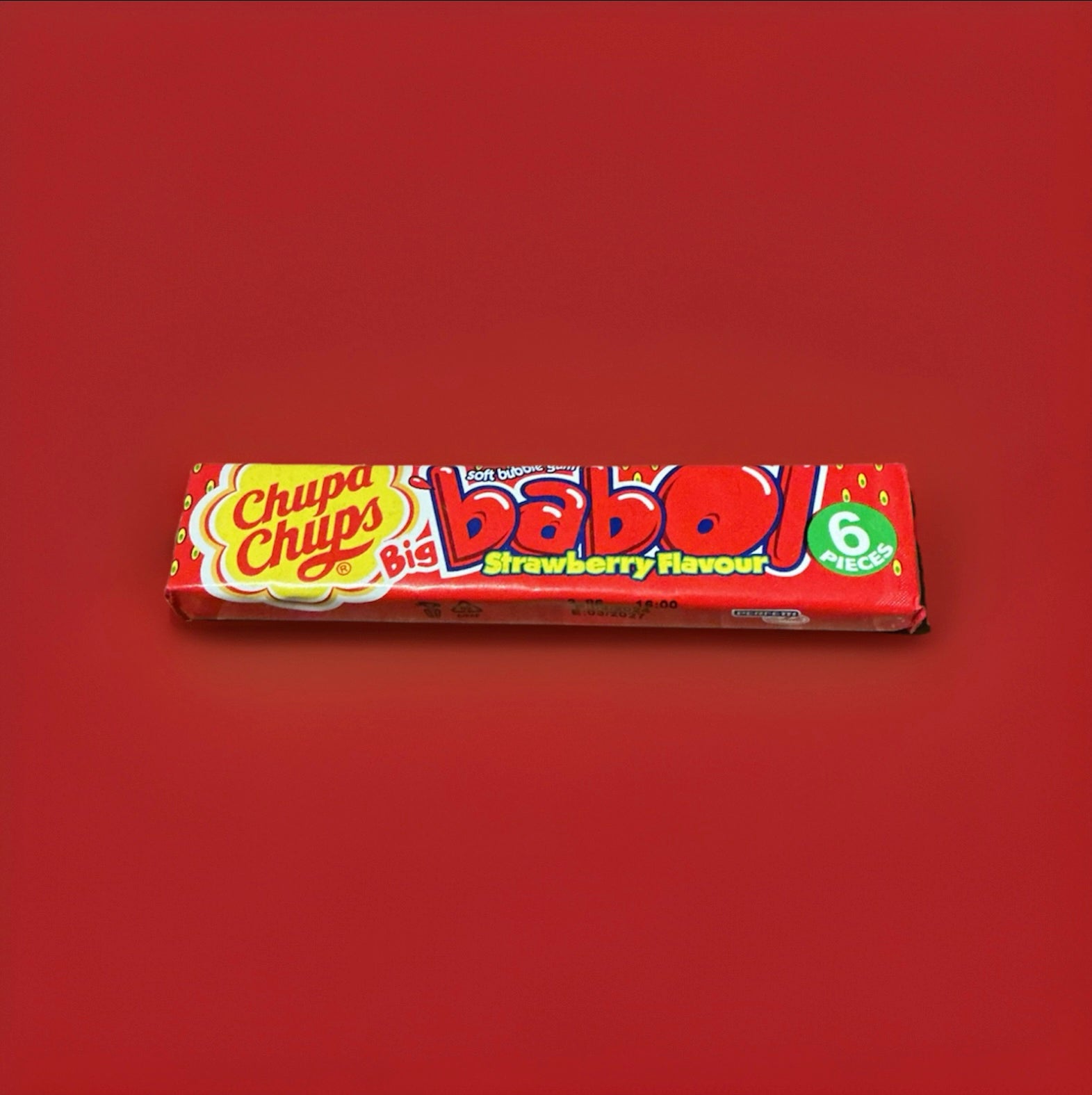 Strawberry flavoured bubblegum squares in a red wrapper on a red background 