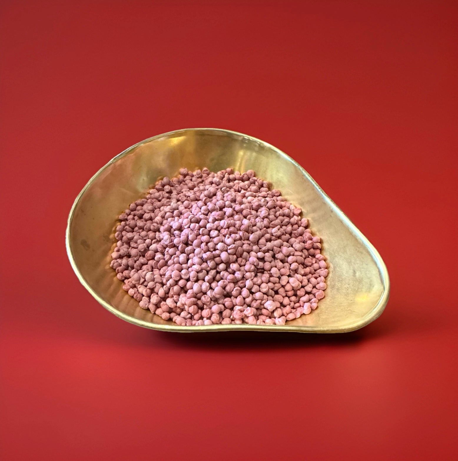Purple coloured Vimto flavoured millions in a gold bowl on a red background 