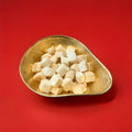 Coconut Toasties in a gold bowl on a red background 