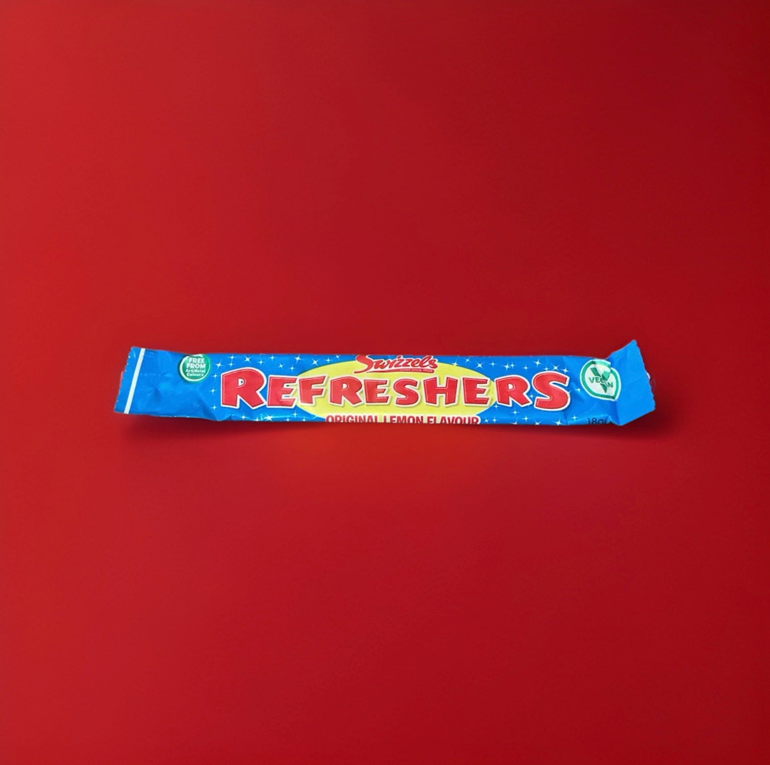Original lemon flavoured blue and yellow wrapped refresher chew bar on a red background 