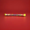 Wrapped long fruit salad flavoured jelly sweet with sprinkles on in a yellow and pink wrapper 