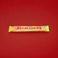 Wrapped yellow tropical flavoured chew bar on a red background 