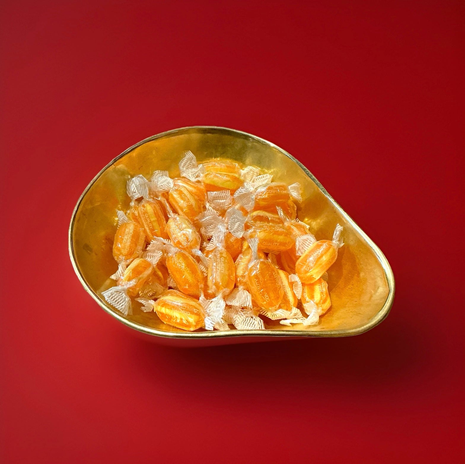 Light and dark orange striped sweets with a pineapple flavour and a sherbet centre 