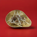 Hard boiled individually wrapped toffee lolly in a gold bowl on a red background 