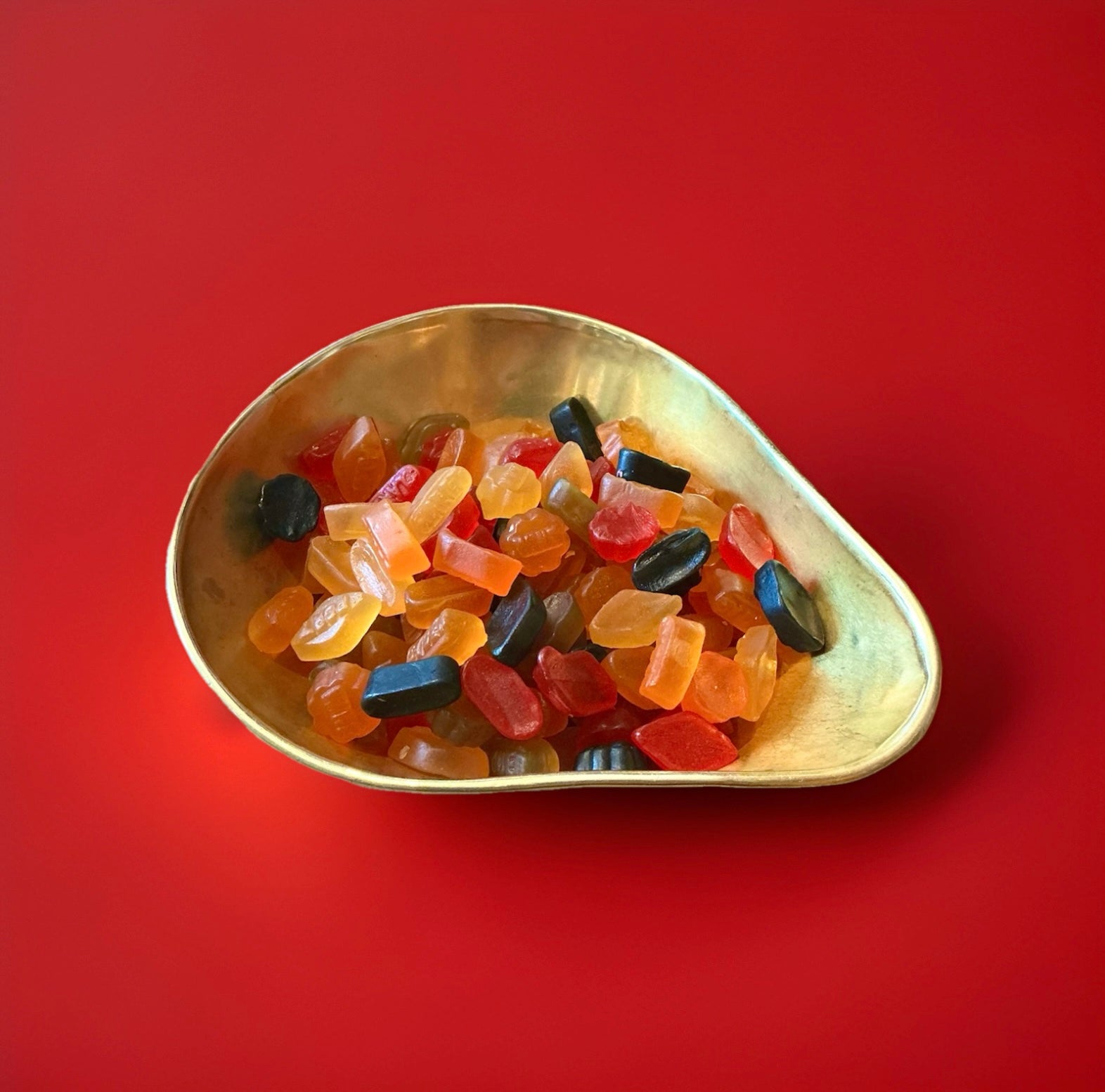 Lion Wine Gums in a gold bowl with a red background 