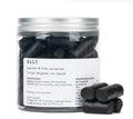 A jar of slow cooked salty liquorice with a white background 
