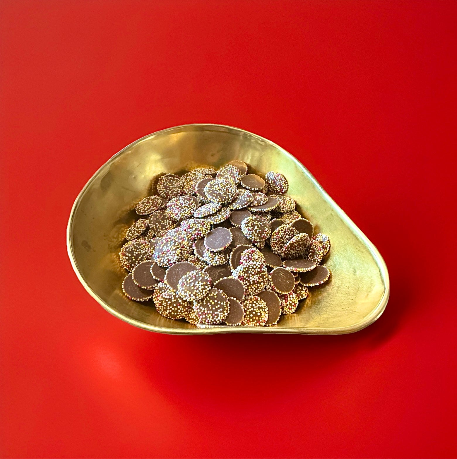 Milk chocolate Jazzies in a gold bowl on a red background 