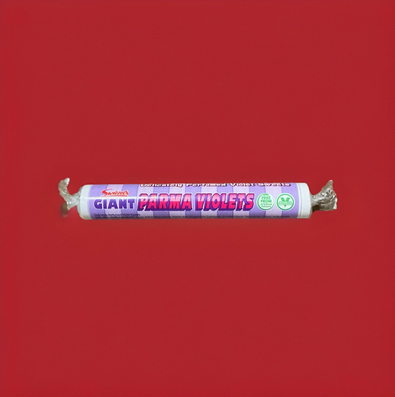 Parma violet flavoured disc shaped sweets in a purple wrapper on a red background 