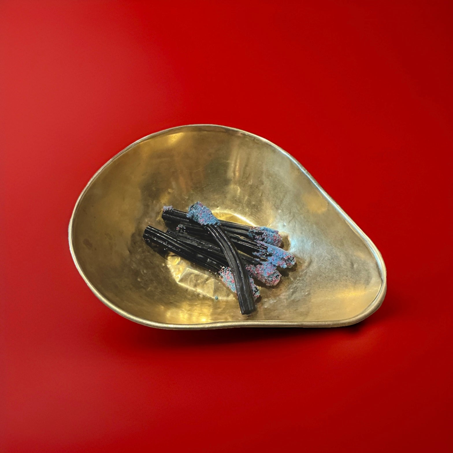 5 Barrett soft liquorice wands in a gold bowl with a red background 