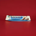 Two stick of coconut fondant wrapped in crunchy pastry and coated in milk chocolate in a blue and white wrapper on a red background 