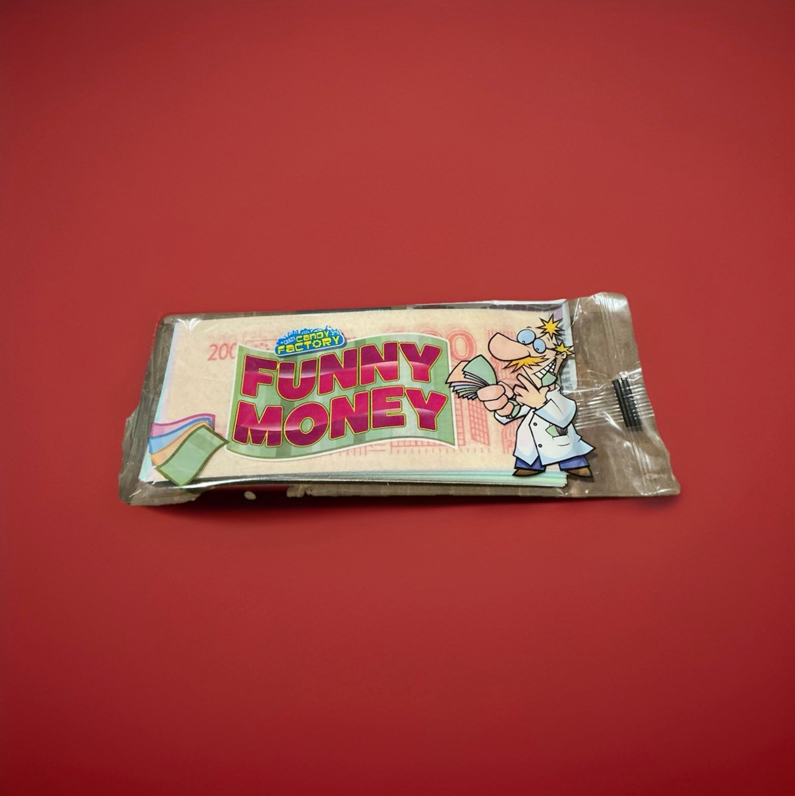 Sheets of rice paper printed to look like money in a clear plastic wrapper on a red background 