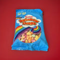 Multicoloured fruit flavoured puffed rice in a blue packet with a rainbow on red background 