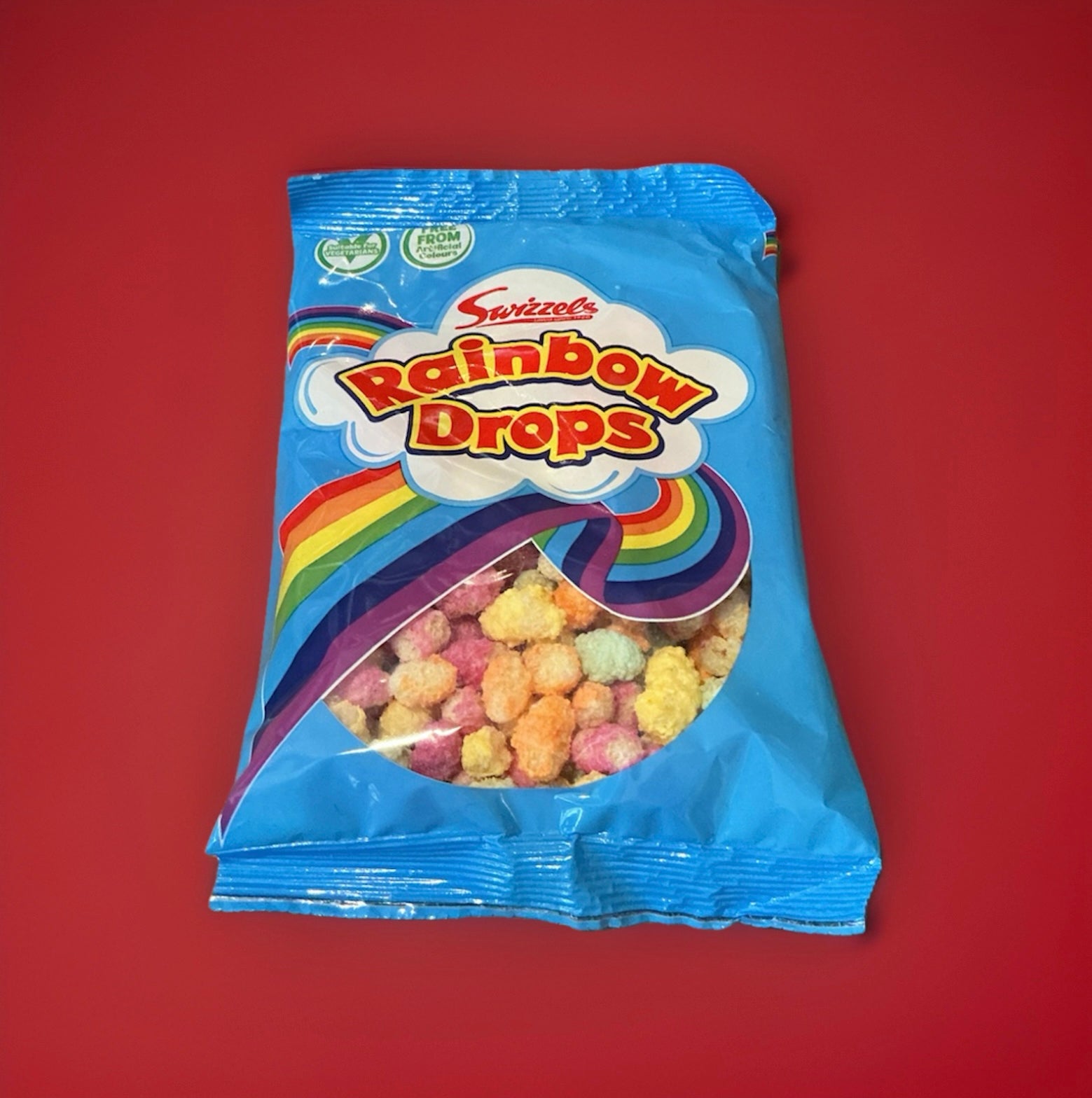 Multicoloured fruit flavoured puffed rice in a blue packet with a rainbow on red background 