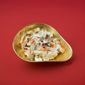 Wrapped mixed fruit flavoured hard boiled sweets with a soft fruity centre in a gold bowl with a red background 
