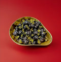 Individually wrapped gold and brown coffee flavoured toffees in a gold bowl on a red background 