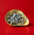 Oval shaped hard boiled voice tablets in a gold bowl on a red background 