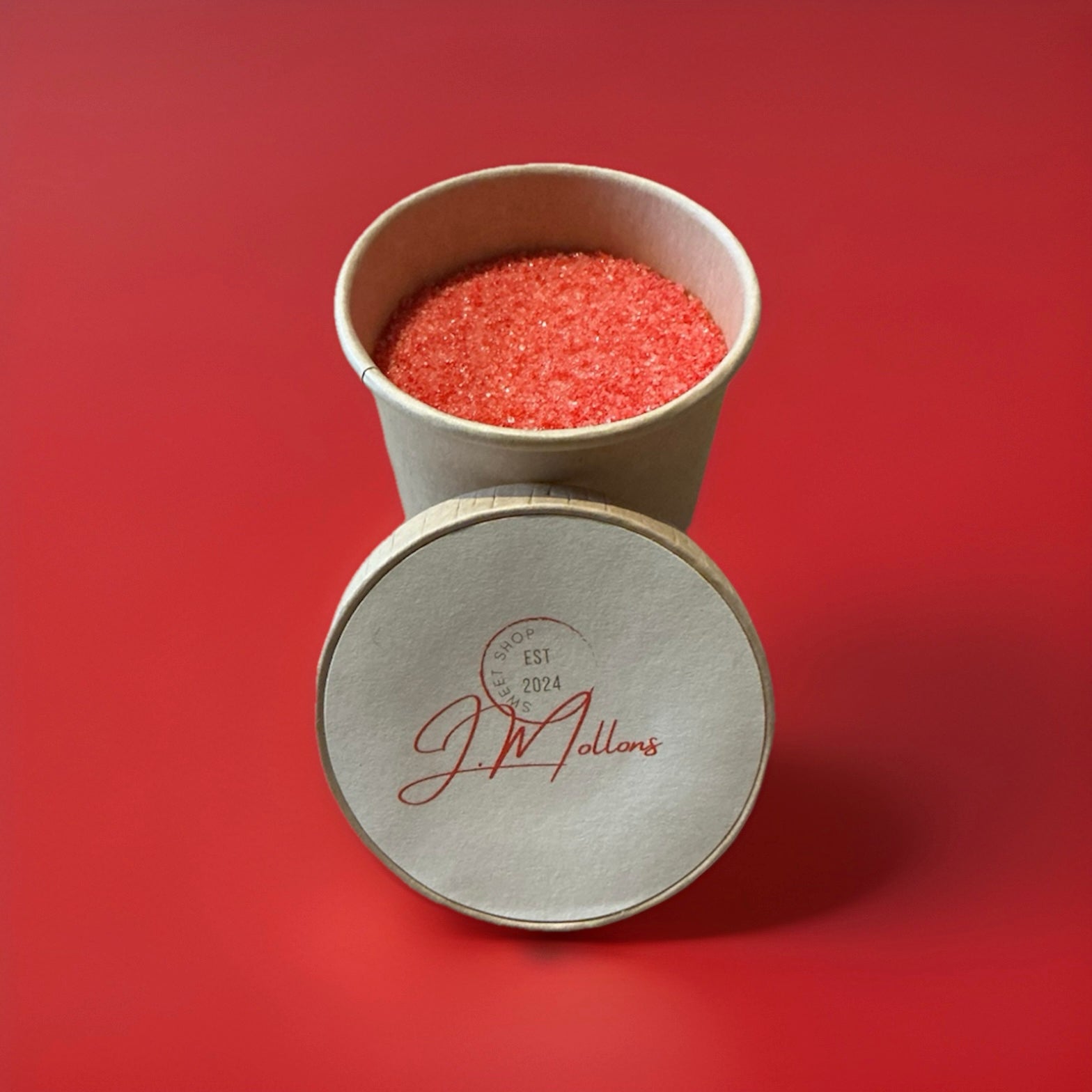 Red strawberry flavoured sherbet in a brown paper pot on a red background 