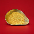 Yellow coloured Banana flavoured millions in a gold bowl on a red background 