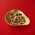 Lucky Tatties cinnamon sweets in a gold bowl on a red background 
