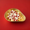 Traditional white and red rock cuttings with a clove flavour in a gold bowl with a red background 