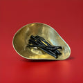 5 Barrett hard liquorice sticks in a gold bowl with a red background 