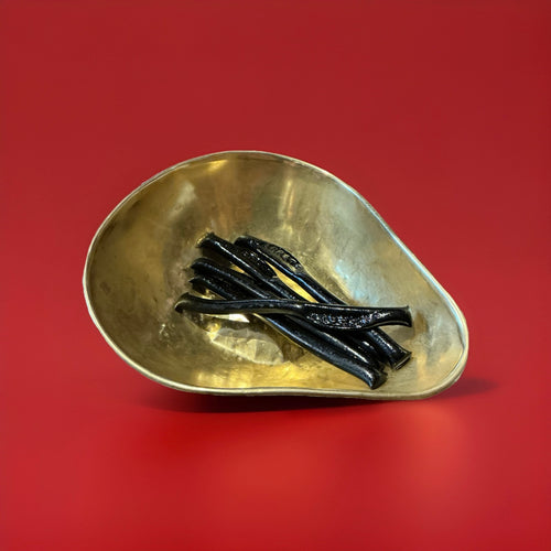 5 Barrett hard liquorice sticks in a gold bowl with a red background 