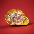 Individually wrapped cherry balsam cough sweets in a gold bowl on a red background 