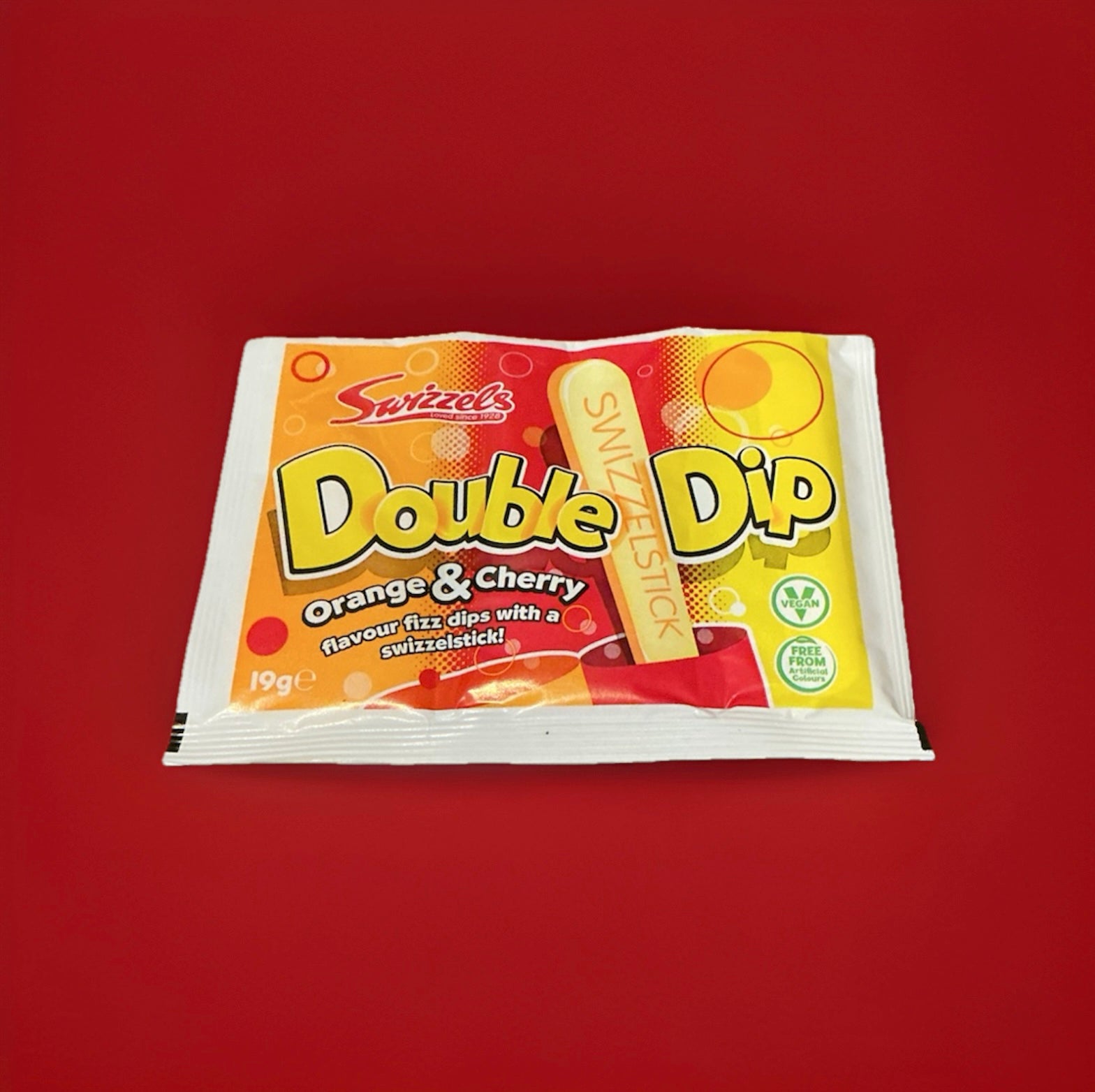 Red yellow orange and white packaged sherbet with a chalky sweet stick lolly for dipping