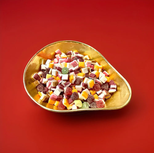 Barratt dolly mixture sweets in a gold bowl on a red background 
