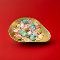mixed flavours of salt water taffy in a gold bowl with a red background 