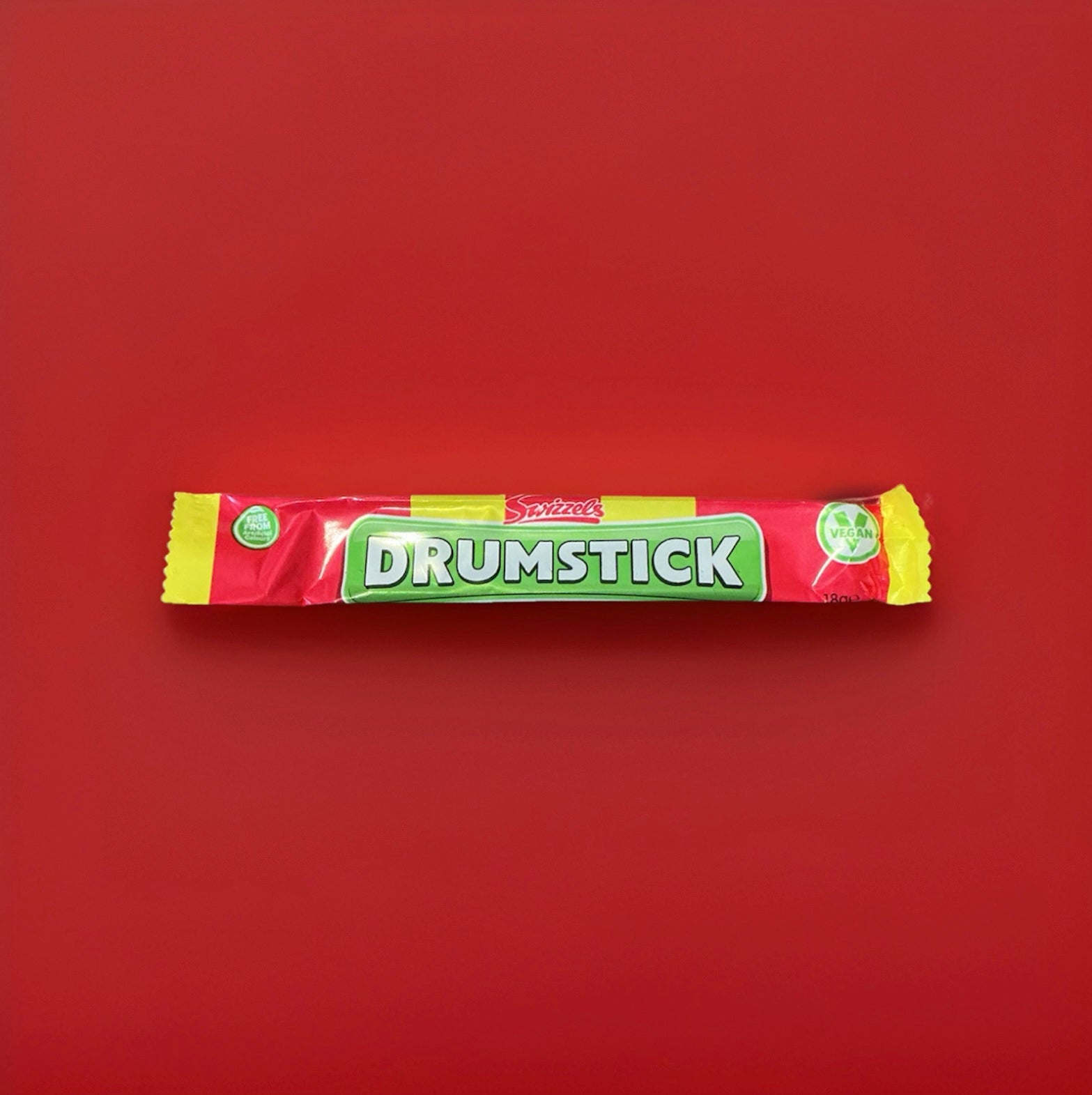 Drumstick lolly flavoured chew bar in a red yellow and green wrapper on a red background 