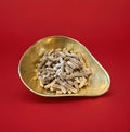 Choc nibble chocolate pellets in a gold bowl on a red background 