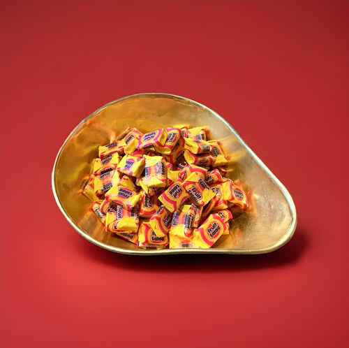 Barratt fruit salad chews in a gold bowl on a red background 