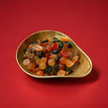 Fruit shaped fruit flavoured Lion Fruit Salad sweets in a gold bowl with a red background 