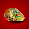 Multicoloured bear shaped jelly sweets with a sour sugar coating in a gold bowl with a red background 