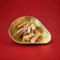 Ross’s whisky fudge chunks in a gold bowl with a red background 