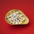 Round shaped iron brew flavoured Bon Bon’s in a gold bowl with a red background 